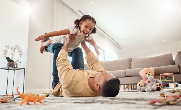 Happy family, father and girl playing in a house